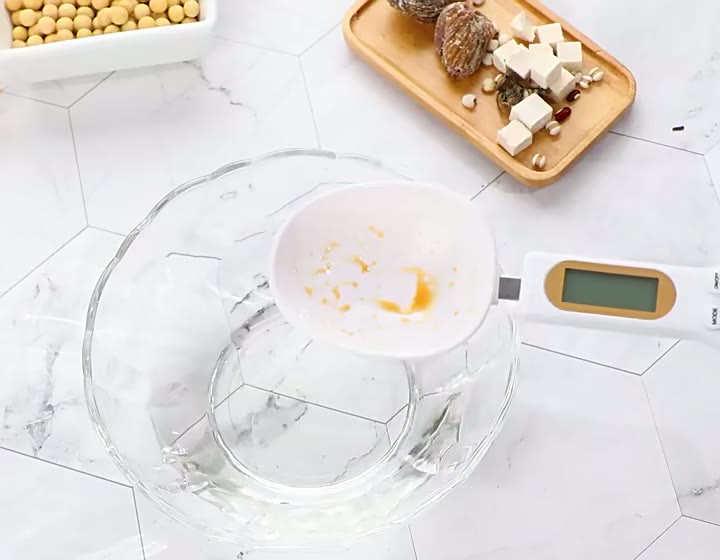 Detachable PrecisionSpoon scoop being rinsed in a glass bowl